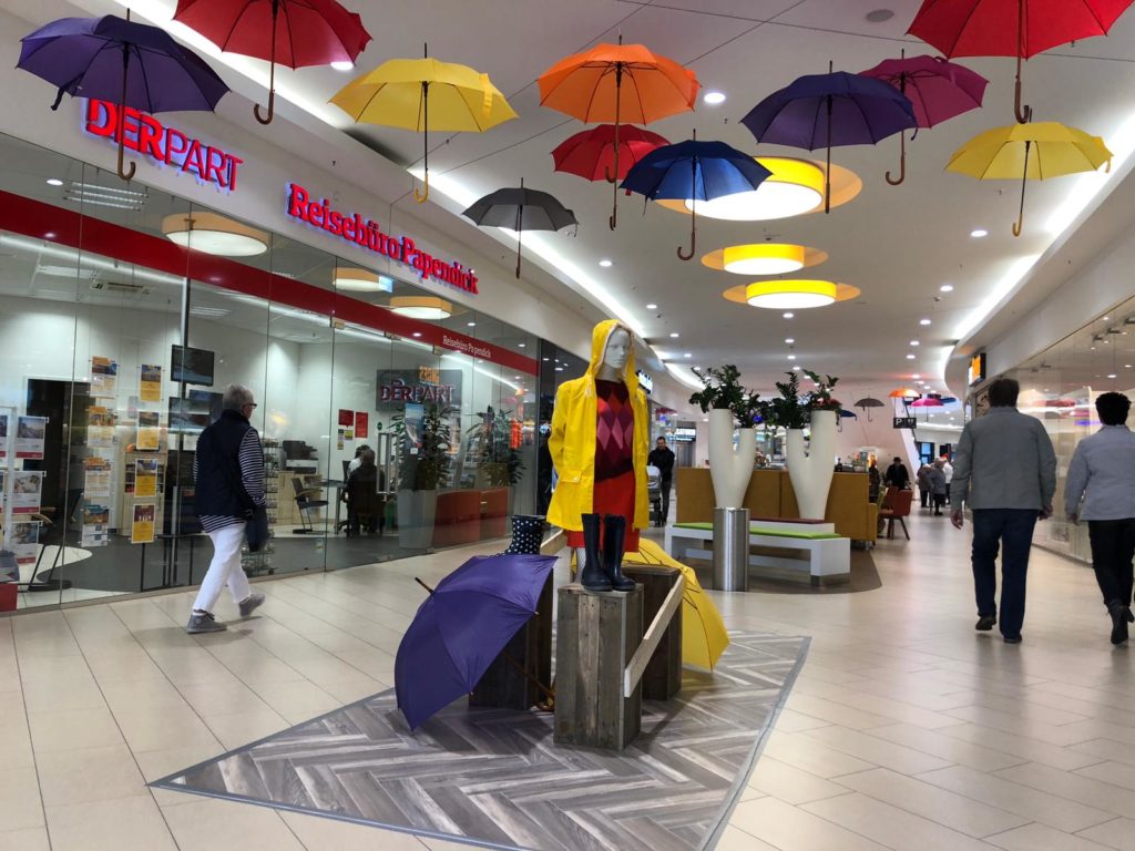 Visual Merchandising in Shopping Center mit Regenschirmen